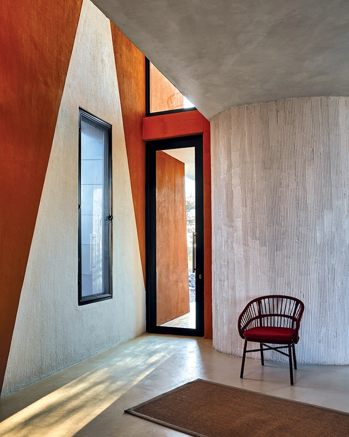 The entrance is a combination of textures and finishes, with a custom-colour Africote floor and a burnt-orange silhouette on the wall in a nod to the Ekipa motif.
