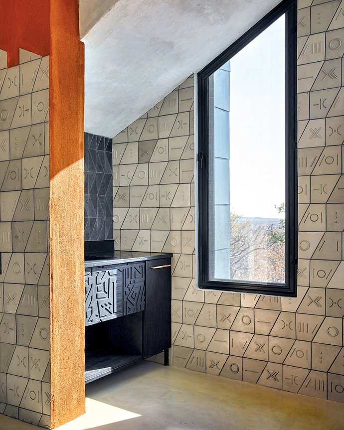 The markings and shapes of the tiles by Wolkberg Casting Studio, along with the engraving in the joinery by Namibian furniture brand Cajaka, pay further homage to the Ekipa motif.