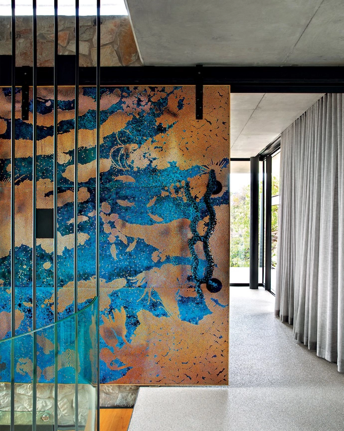 A custom sliding door by Cape Town-based artist Stanislaw Trzebinski leads to the main bedroom.