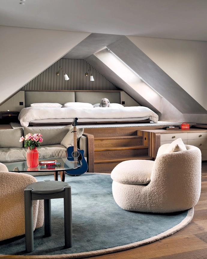 A kid’s bedroom is cleverly split to accommodate a bed platform and a living area with a built-in sofa and desk. The swivel chairs are from Hertex and Sofa Company, and the Noguchi table is from Il Lusso. 