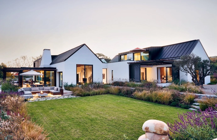 Designed in the style of a Cape langhuis, the home is a modern farmhouse. Two barns laid out over three levels are connected by courtyards and a rooftop terrace. By placing the house on the lowest contours of the site, architect Arn Erasmus ensured that the building feels grounded and that, with time, the landscaping will ground it further. In the courtyard that connects the entrance hall to the living area, a life-sized bronze-cast sculpture of a shepherd tree by artist Nic Bladen is a serious wow factor.