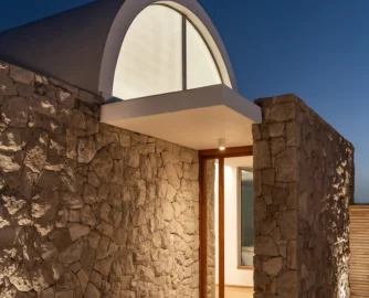 Thoughtful lighting casts the home’s stonemasonry in sharp relief.