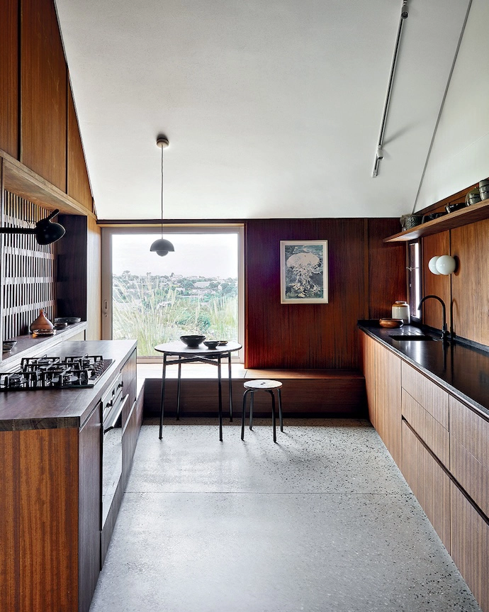 The breakfast nook at the far end of the kitchen is furnished with a petite table and stool by Pedersen + Lennard. 