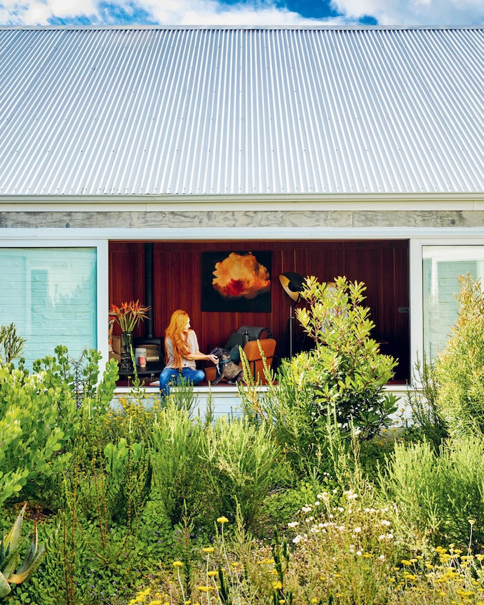 Large sliding windows open from the TV lounge onto a lush courtyard garden filled with indigenous and endemic plants.