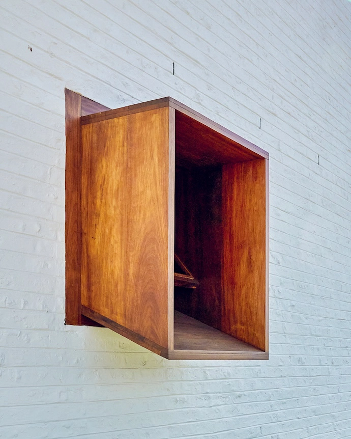 The doorway and windows on one facade are surrounded by wooden frames, custom-designed to protect each opening by architect Guillaume Pienaar.