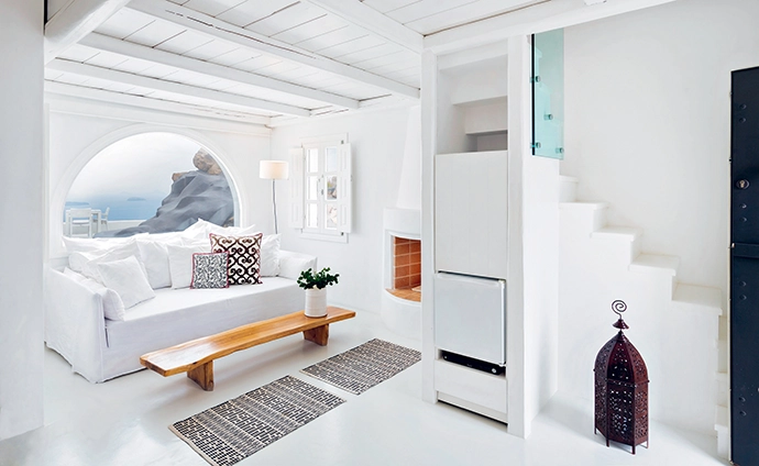 Villa Elidami’s living room, with a fireplace and west-facing views of the Aegean.