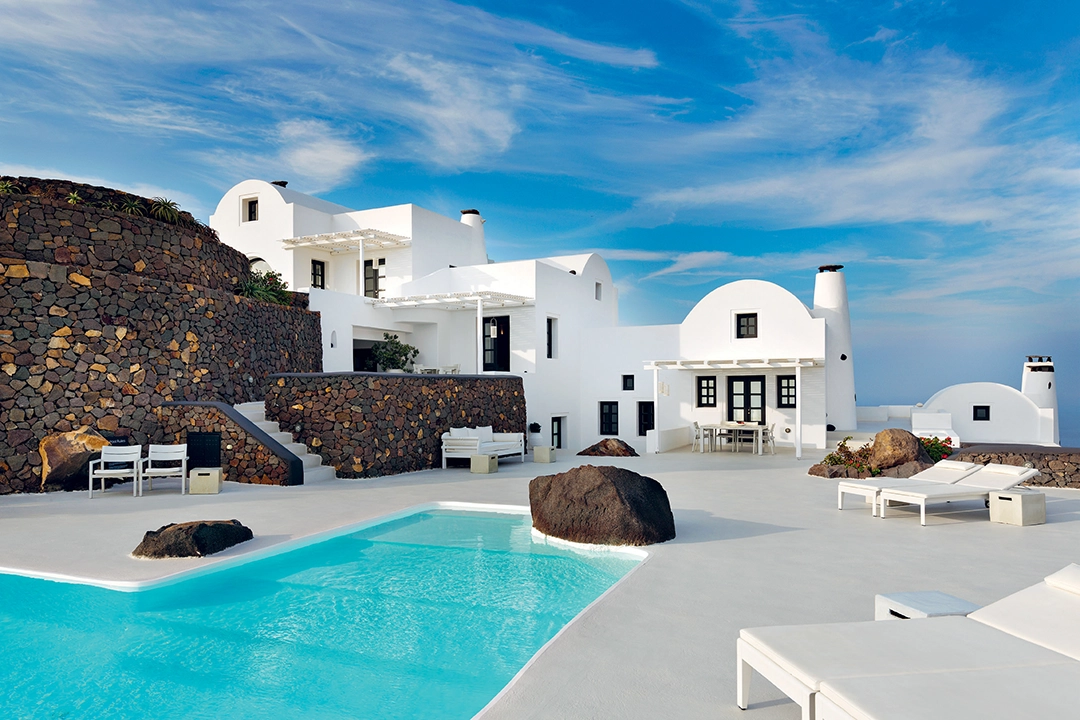 The seven villas, protected by terraced stone retaining walls that curl around the property, all have a unique layout, and are all minimalist in style and predominantly white, in keeping with traditional Cycladic architecture. Each villa has also been given an equally traditional Santorinian woman’s name