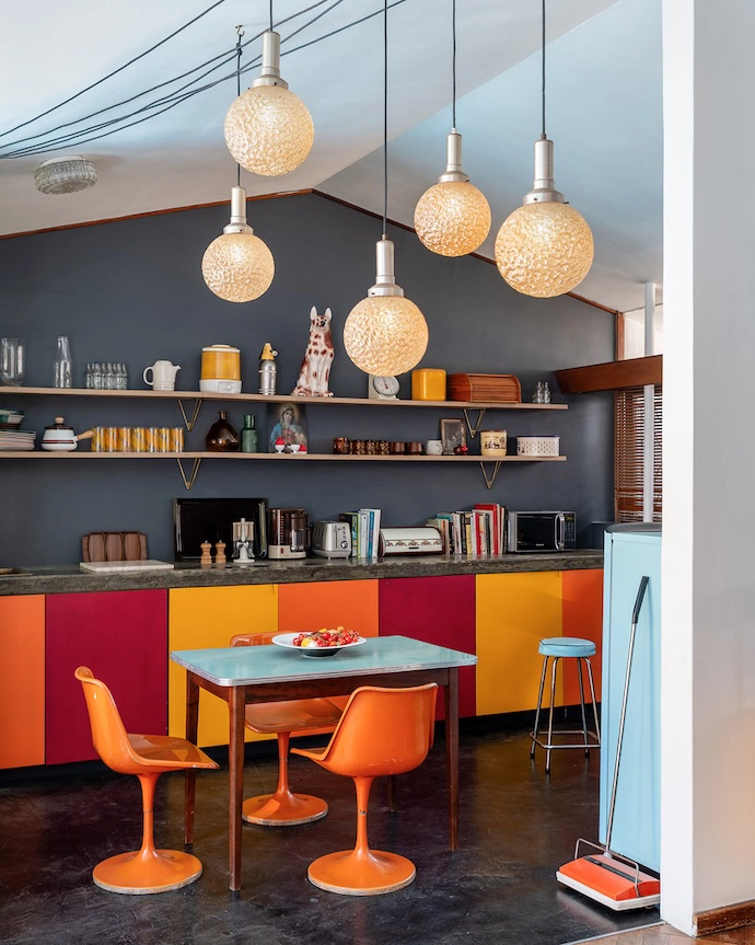 The Mid-century Modern palette of the kitchen cabinetry anchors the home’s enviable collection of designer finds, including the 1950s Tulip chairs by Eero Saarinen for Knoll.
