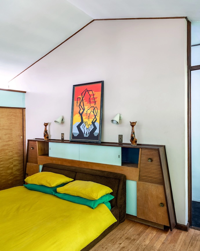 Echoing the diagonal lines of the home, the Mid-century Modern headboard seamlessly integrates into the timber-accented bedroom.