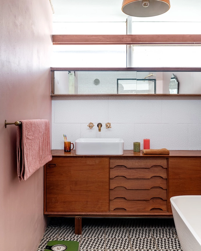 Retro hound’s-tooth tiles, a vintage scale and a Danish Mid-century sideboard are juxtaposed with contemporary sanitaryware and lighting in the bathroom.