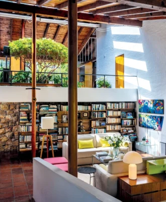 The double-volume living area includes a bespoke bookcase/room divider designed by Gawie. Behind it is the passage to the guest bedroom and bathroom. The room is the ideal space to show off some of owner Lana Hudson’s art collection, which includes works by Clive van den Berg and Robert Hodgins.