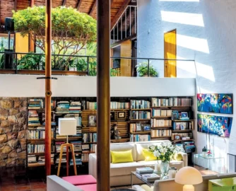 The double-volume living area includes a bespoke bookcase/room divider designed by Gawie. Behind it is the passage to the guest bedroom and bathroom. The room is the ideal space to show oﬀ some of owner Lana Hudson’s art collection, which includes works by Clive van den Berg and Robert Hodgins.