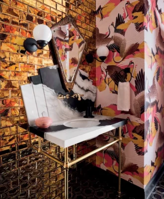 Chicago interior designer SuzAnn Kletzien opts for over-the-top maximalism in this guest bathroom, combining Milton & King’s Cranes wallpaper with high-gloss metallic tiles, hexagonal floor tiles and a marble vanity. The look works not only because she’s chosen a contained colour palette, but because she pairs matt and reflective surfaces.