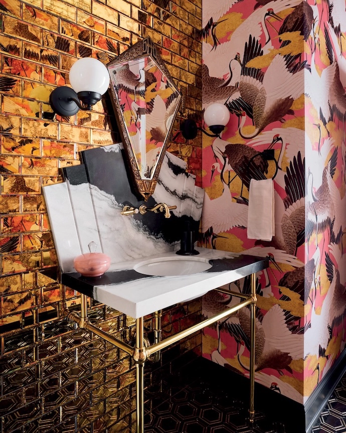 Chicago interior designer SuzAnn Kletzien opts for over-the-top maximalism in this guest bathroom, combining Milton & King’s Cranes wallpaper with high-gloss metallic tiles, hexagonal floor tiles and a marble vanity. The look works not only because she’s chosen a contained colour palette, but because she pairs matt and reflective surfaces.