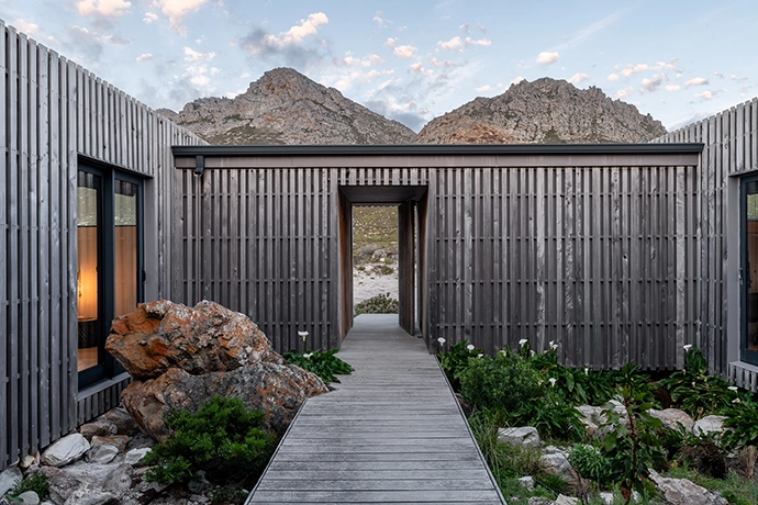 Flanked on either side by bedrooms, the entrance to the house houses wine racks and bookshelves.