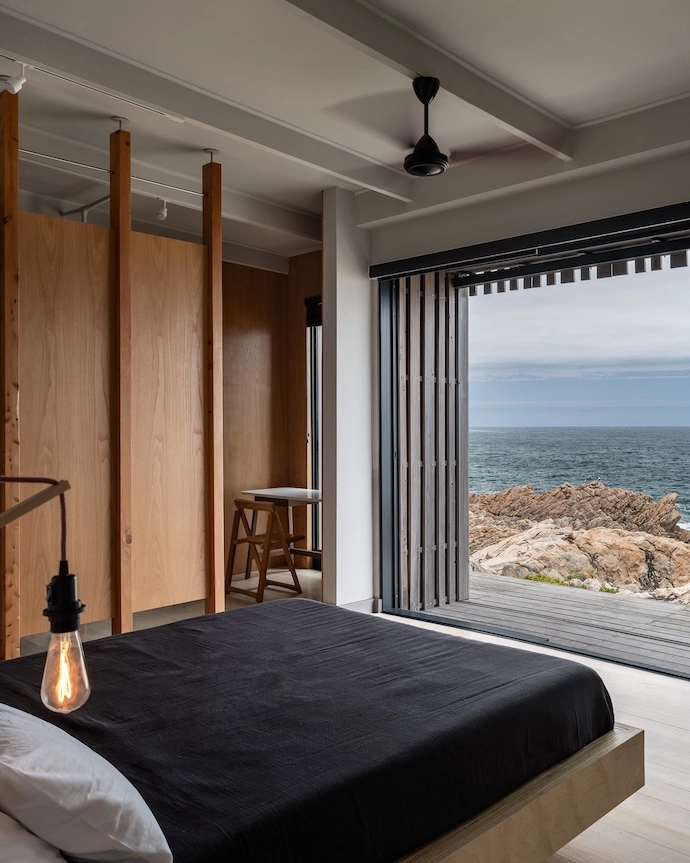 The main bedroom overlooks the ocean and, like the rest of the house, can be shuttered to protect against the elements.