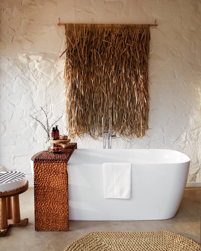 Ballito-based interior designer Michele Throssell off sets the sleek surface of a freestanding tub with textured whitewashed rock walls in this KwaZulu-Natal project. Other tactile surfaces in the bathroom drive home the look. Source similar bathtubs at Duravit.
