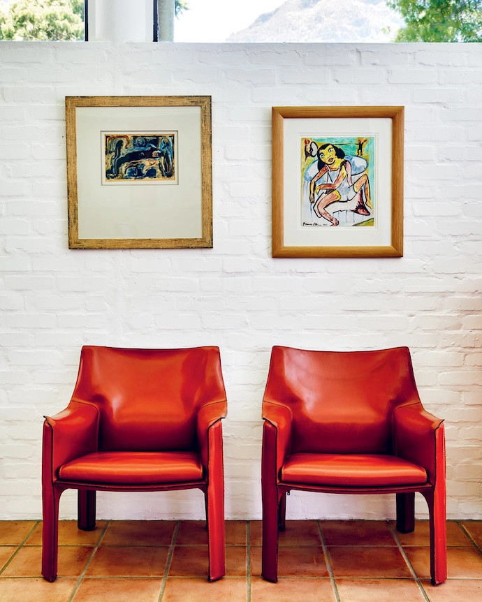 Two Irma Stern originals keep good company above a pair of Cassina Cab 413 armchairs by Mario Bellini.