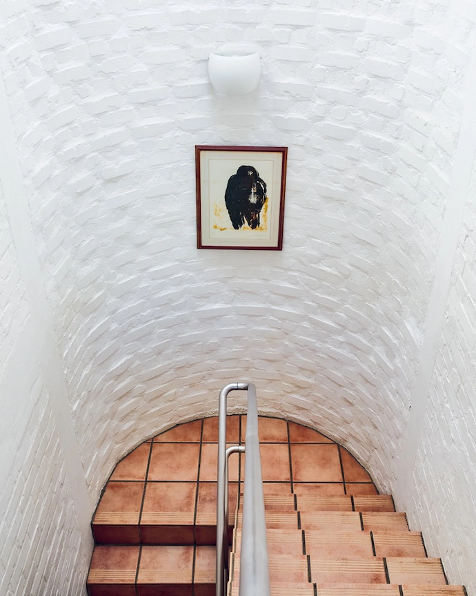 Halfway up (or halfway down?), a Herman van Nazareth original looks onto the cylindrical stairwell.