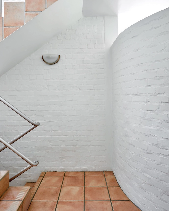 A skylight floods the space with sun, playing up the texture of the bagged brick walls and encouraging upward glances.