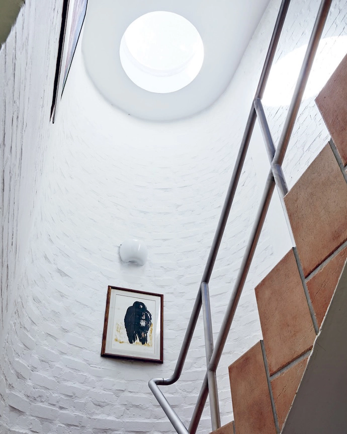 Halfway up (or halfway down?), a Herman van Nazareth original looks onto the cylindrical stairwell.