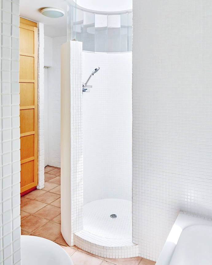 An echo of the stairwell, the cylindrical shower has its own skylight.