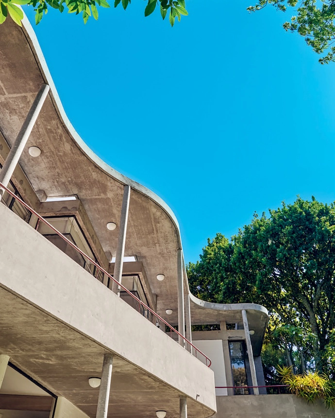 An undulating concrete loggia shades the top floor.