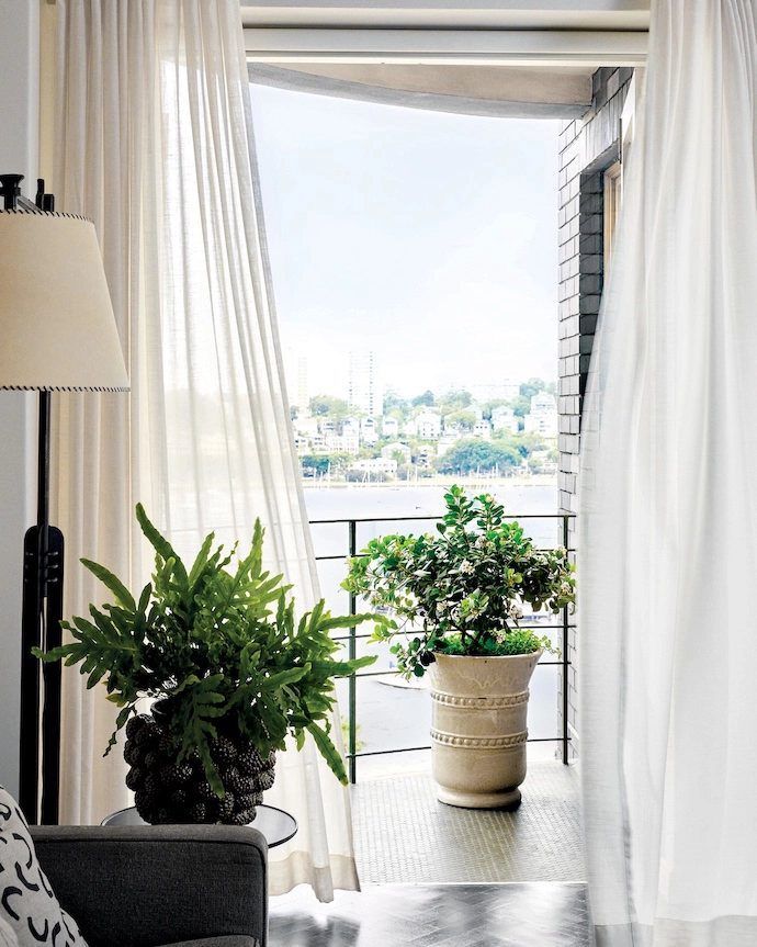 Leading to the distinctive curved balcony, the living room features a three-seater sofa and a 1950s Italian lamp.