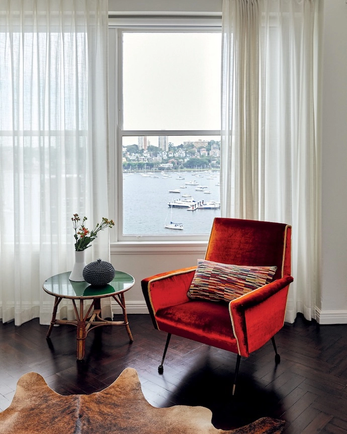 A vintage armchair has been reupholstered in red velvet.