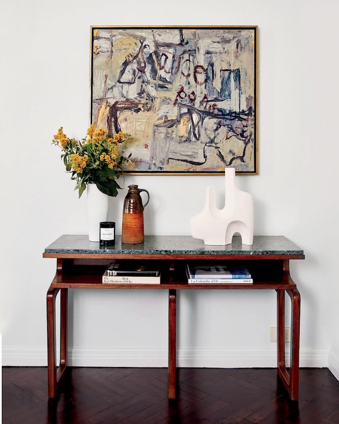 A painting by Elisabeth Cummings hangs above a 1950s console table with marble top.