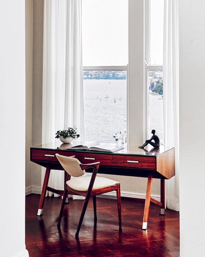 Looking over Elizabeth Bay, the study is furnished with a Henning Jensen & Torben Valeur rosewood desk, and Model 42 chair by Kai Kristiansen.