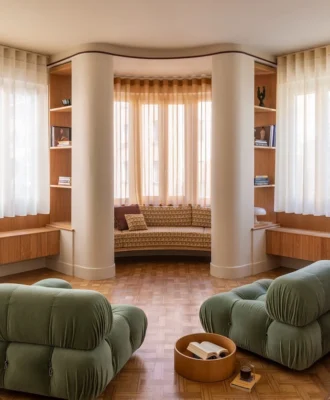 The living room with original parquet flooring featuring Camaleonda sofas, designed by Mario Bellini for B&B Italia; Nessino table lamp by Artemide; curtains in FISCHBACHER fabric 113/117/132; and custom bench in Relief Cammello fabric by l’Opificio.
