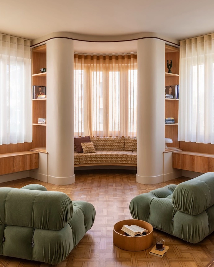 The living room with original parquet flooring featuring Camaleonda sofas, designed by Mario Bellini for B&B Italia; Nessino table lamp by Artemide; curtains in FISCHBACHER fabric 113/117/132; and custom bench in Relief Cammello fabric by l’Opificio.