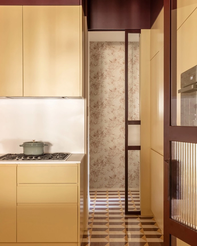 Inside the kitchen with a view of the Jon Burgundy wallpaper by Sandberg and custom Graniglie D’Ascenzi flooring.