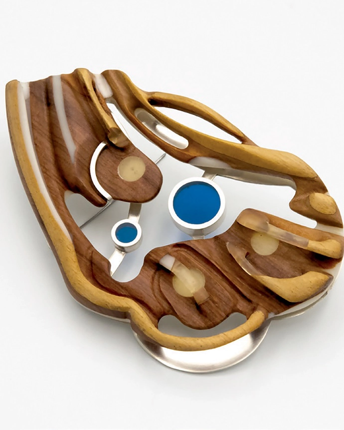 Siboneni (See Us) brooch (2022) in Jelutong, resin and silver by Dr Bongani TP Mashange.