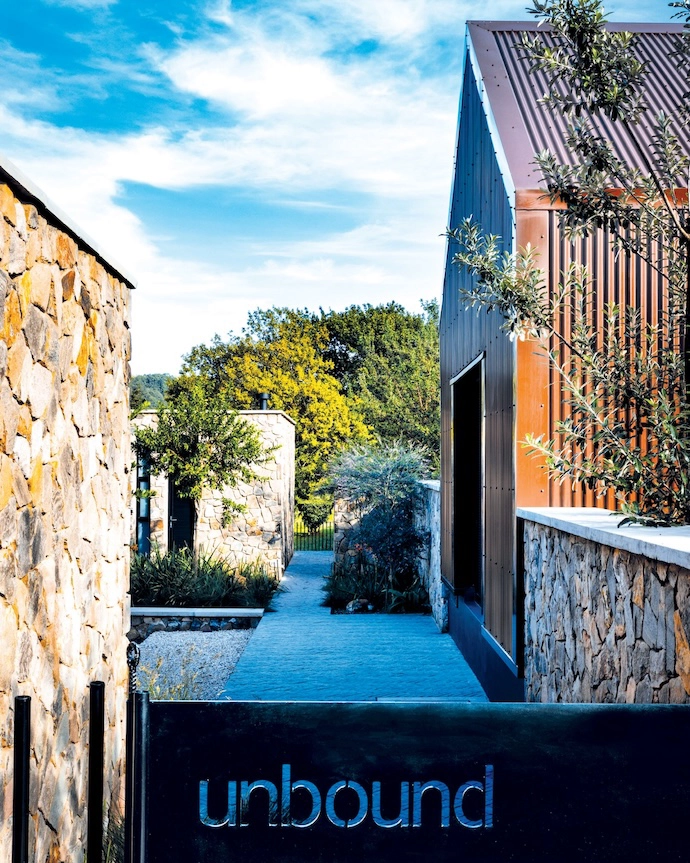The entrance through a low gate laser-cut with the word “unbound” – the name given to this weekend getaway outside Dullstroom – shows how the design opens up vistas between the buildings.