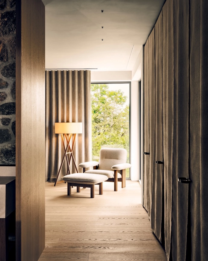 Scandi-inspired pieces, including a lounge chair and ottoman by Audo Copenhagen, add comfort to the primary bedroom.