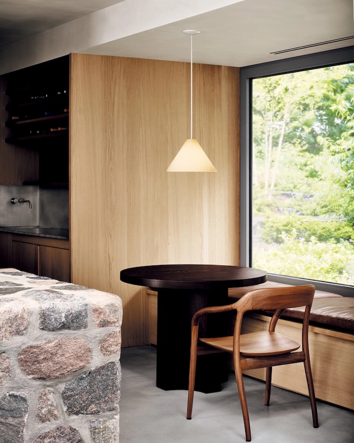 A breakfast alcove includes a red oak table and a Tako armchair by Naoto Fukasawa.