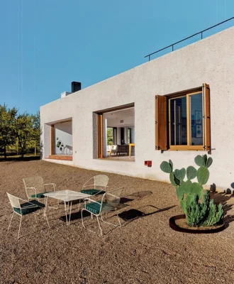 The southeastern facade of the house with views over the Karoo landscape. Protruding from the wall, you can see one of the exterior waterspouts designed by the architects. The walls thicken at specific points, allowing for hidden rainwater downpipes and other services.