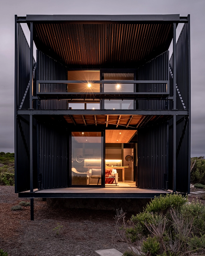 Lightweight aluminium slats, seen here flanking the patios, provide an extra layer of sun protection, while the hinged screens can be closed when the cabin is not in use.