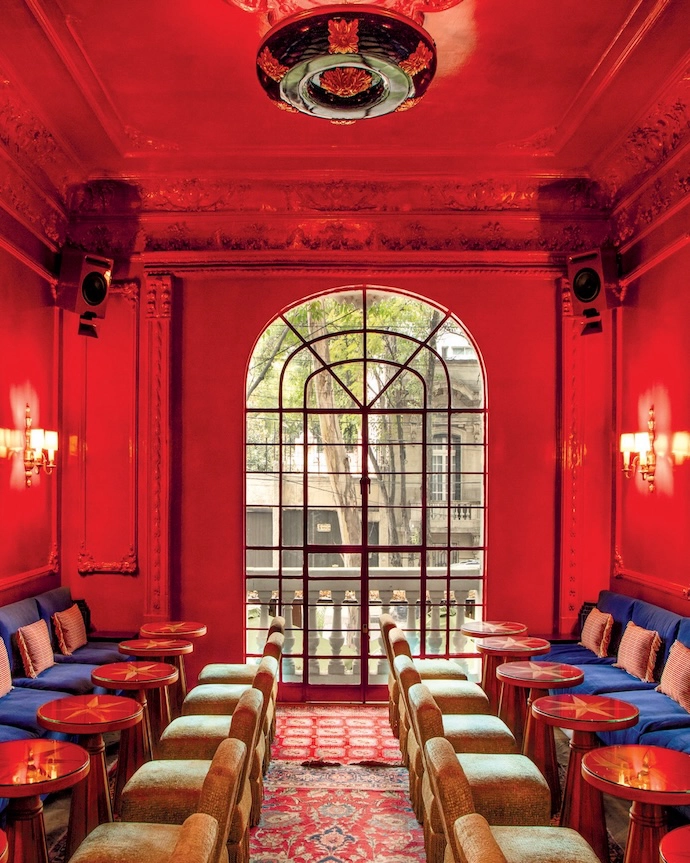 The interior of El Desconocido, a cultural club in Mexico City, features vibrant red gloss-lacquered walls.