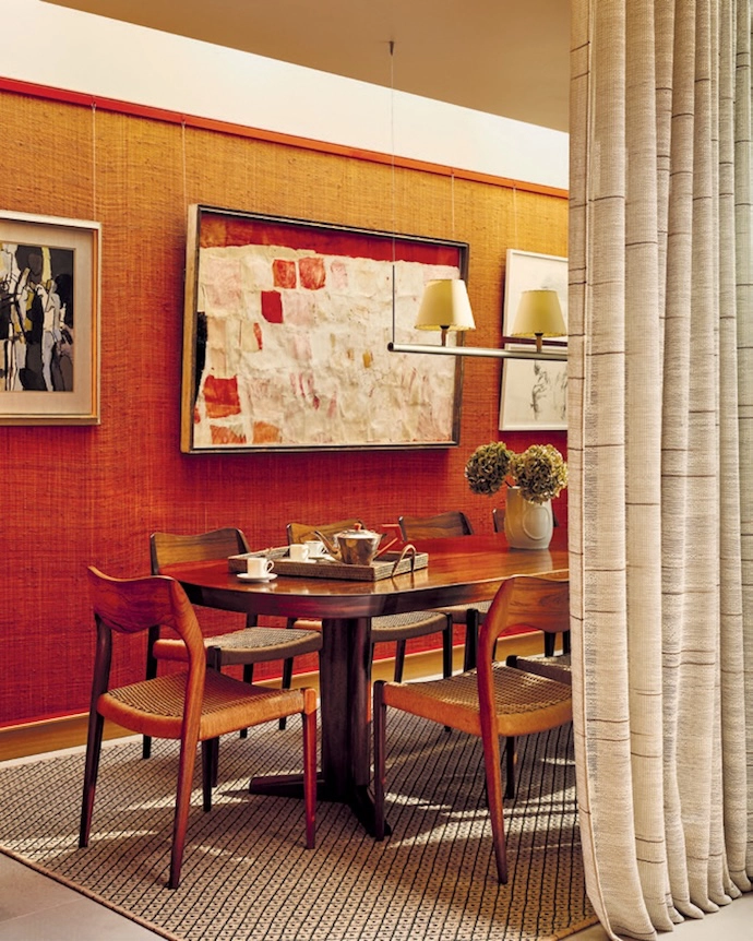 At Palace Gardens residential project in Notting Hill, London, warm terracotta hues and sage-green contrasts dominate the palette – in the entryway, the lounge anchored by a curved sofa, the dining area with its textured wallpaper, and the deep-red marbled wallpaper that’s been used in the guest bathroom. The kitchen continues the earthy aesthetic with luxe stone surfaces.