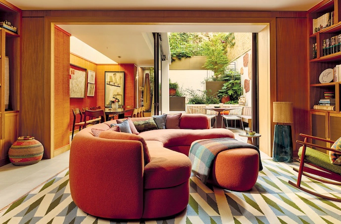 At Palace Gardens residential project in Notting Hill, London, warm terracotta hues and sage-green contrasts dominate the palette – in the entryway, the lounge anchored by a curved sofa, the dining area with its textured wallpaper, and the deep-red marbled wallpaper that’s been used in the guest bathroom. The kitchen continues the earthy aesthetic with luxe stone surfaces.