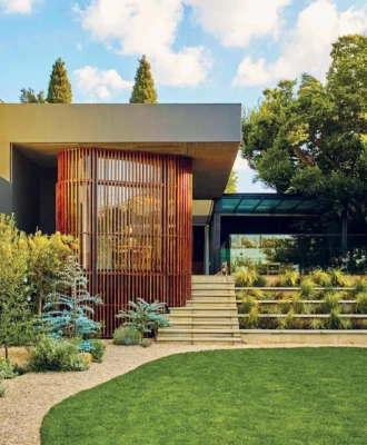 Situated on a relatively narrow, sloped piece of land, Erica and Werner Schalkwyk’s Johannesburg home has been designed by Ruan Marsh of Monograph Architects to manage its level changes, maximise natural light, and continually link the indoor spaces to the beautifully landscaped garden. The slatted wooden section encloses the kitchen-diner.