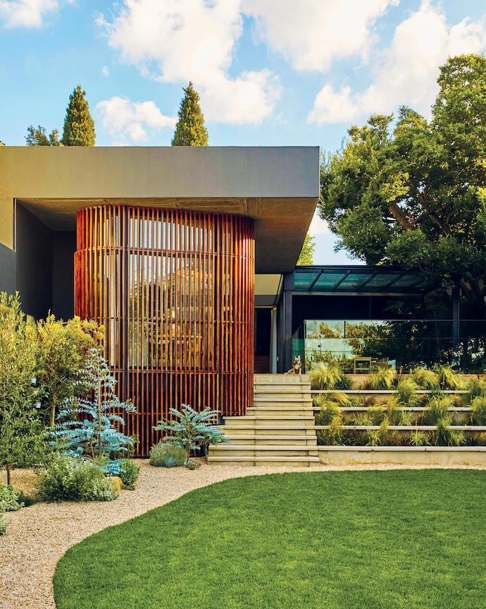 Situated on a relatively narrow, sloped piece of land, Erica and Werner Schalkwyk’s Johannesburg home has been designed by Ruan Marsh of Monograph Architects to manage its level changes, maximise natural light, and continually link the indoor spaces to the beautifully landscaped garden. The slatted wooden section encloses the kitchen-diner.