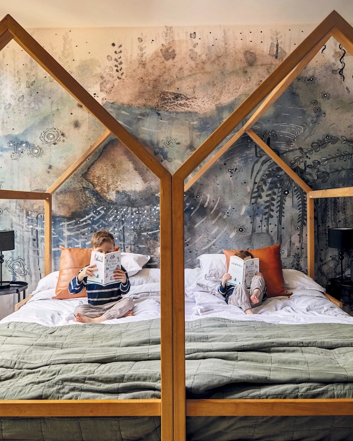 The house-silhouette beds in the boys’ bedroom are by Mike Made This, and the fantasy landscape wallcovering is by Caitlin Mkhasibe, from Robin Sprong.