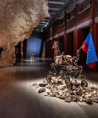View of Reverse Futures exhibition showing Paula Gaetano Adi, Guanaquerx (2024) in the foreground, and Georgia Munnik, The Strangling Fruit (2026) at left; with Cave_bureau’s installation Shimoni Slave Cave (2022–2023) in the background.