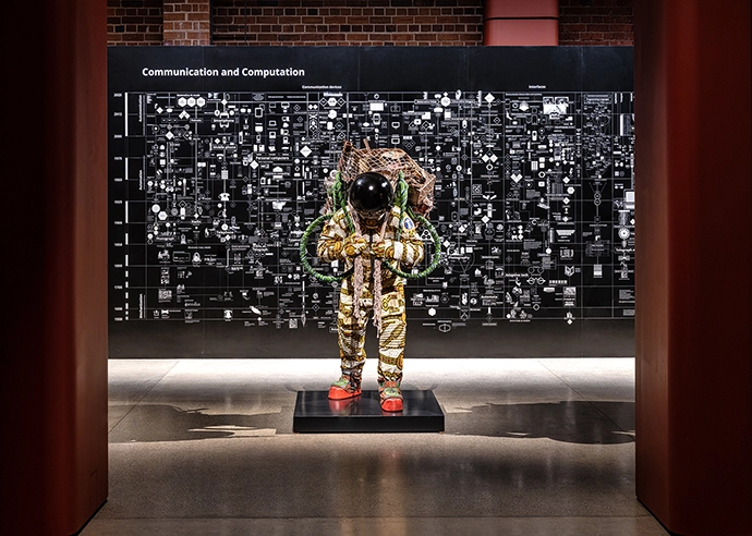 Yinka Shonibare, Refugee Astronaut X (2024), and in the background, Calculating Empires: A Genealogy of Technology and Power since 1500 (2023) by Kate Crawford and Vladan Joler, in the Reverse Futures exhibition.