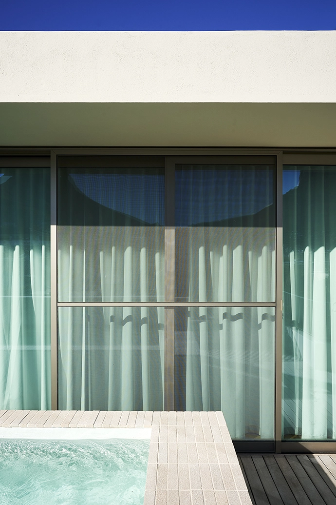 Clean lines, calm water, and glazing that disappears into the design – the pool terrace at Reynaers Haus.