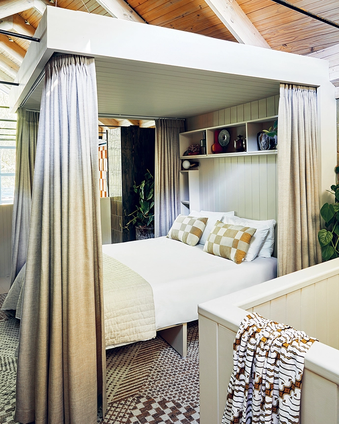 The canopy bed, designed and built by Jonty, creates a soft enclosure within the double volume of the studio. Curtains control the early morning light from the skylights and windows.